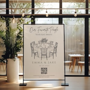 以下が含まれることがあります： 「Our Favorite People」と「Your Seat Awaits」の文字が入った、白黒の結婚披露宴の看板。ゲストのために用意された丸いテーブルのイラストがあり、「EMMA & JAKE」の名前と「10.20.2025」の日付が記載されています。QRコードも含まれています。