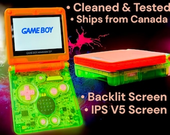 May include: A bright orange and green Game Boy Advance SP with a backlit IPS V5 screen. The console has a clear green shell and a translucent orange top. The screen displays the words "GAME BOY" in blue.