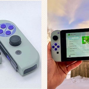May include: A gray and purple Nintendo Switch controller with a retro design. The controller has a purple D-pad and four purple face buttons. The controller is in two pieces, and the right piece has a black analog stick.