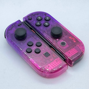 May include: A clear purple and pink Nintendo Switch Joy-Con controller with black buttons and joysticks.
