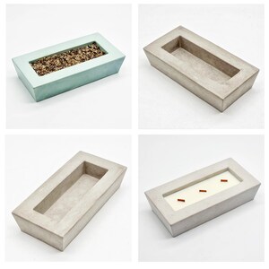 Peut inclure: Quatre plateaux rectangulaires en béton, deux sont gris clair et deux sont bleu-vert clair. Les plateaux ont une dépression rectangulaire au centre. L'un des plateaux gris clair a quatre petits bâtonnets orange fins dans la dépression.