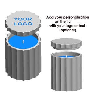 May include: A gray candle with a blue wax interior and a gray lid. The lid has a space for personalization with a logo or text. The text "YOUR LOGO" is printed on the lid.