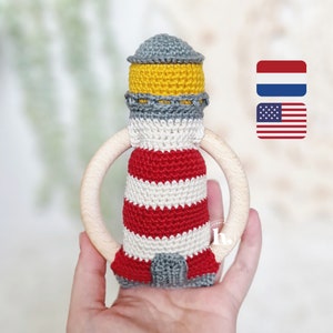 May include: A crocheted lighthouse toy with red and white stripes, a yellow and gray roof, and a wooden teething ring.