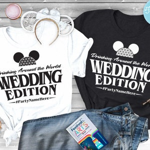 May include: Two white t-shirts with black text and a black and white Mickey Mouse ear silhouette with a Spaceship Earth graphic. The text reads "Drinking Around the World Wedding Edition #PartyNameHere".
