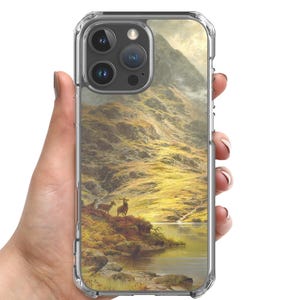 Może przedstawiać: Przezroczyste etui na telefon z pejzażem przedstawiającym dwa jelenie nad jeziorem. Grafika przedstawia pasmo górskie w odcieniach złota i zieleni.