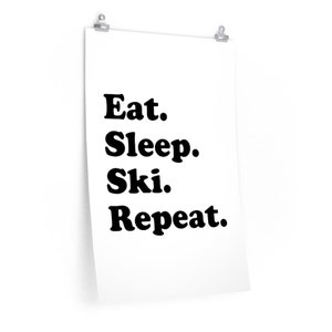 Op de afbeelding: Zwart-witte poster met de tekst "Eten. Slapen. Ski&euml;n. Herhalen."
