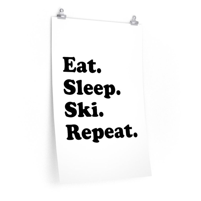 Op de afbeelding: Zwart-witte poster met de tekst "Eten. Slapen. Ski&euml;n. Herhalen."