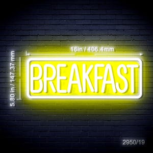 May include: A neon sign with the word "BREAKFAST" in white letters against a yellow background. The sign is rectangular, outlined in white, and measures 16 inches wide and 5.8 inches high. The background is a dark brick wall.