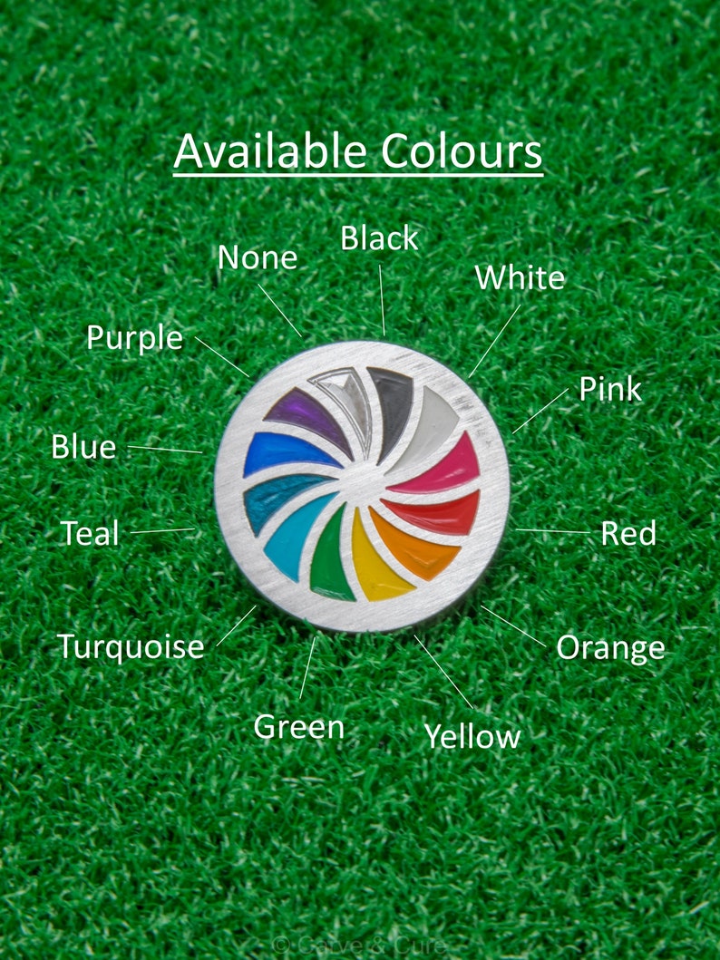 Op de afbeelding: Een zilverkleurige golfbalmarker met een kleurrijk spiraalontwerp, met kleuren als paars, blauw en rood. De tekst "Available Colours" staat bovenaan, met kleurnamen rond de marker.