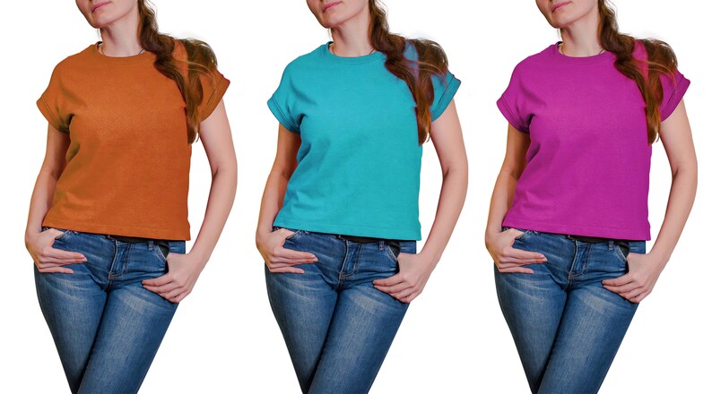 K&ouml;nnte beinhalten: Drei Frauen tragen T-Shirts in verschiedenen Farben. Die Shirts sind orange, t&uuml;rkis und pink. Alle drei Frauen tragen blaue Jeans.