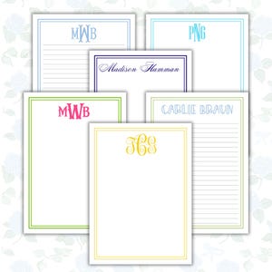 May include: A collection of personalized stationery featuring various designs. Each sheet has a white background with colored borders and custom text or monograms. The colors include blue, green, yellow, and pink. Some sheets have lined pages.
