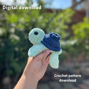 May include: A crochet pattern for a small, green and blue turtle. The turtle is crocheted with a soft, fluffy yarn. The pattern is available for digital download.