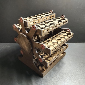 May include: A wooden paint bottle organizer with multiple tiers and circular openings. The organizer has a gear-like design on the side and red accents. It is designed to hold multiple paint bottles, keeping them organized and accessible.
