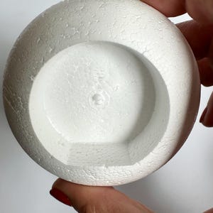 May include: White styrofoam ball with a hollowed out center, perfect for crafting projects.