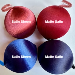 May include: Four round ornaments, two red and two blue, with a satin sheen and a matte satin finish. The ornaments are labeled "Satin Sheen" and "Matte Satin".