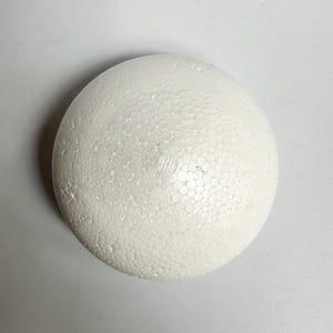May include: A white styrofoam ball with a textured surface.
