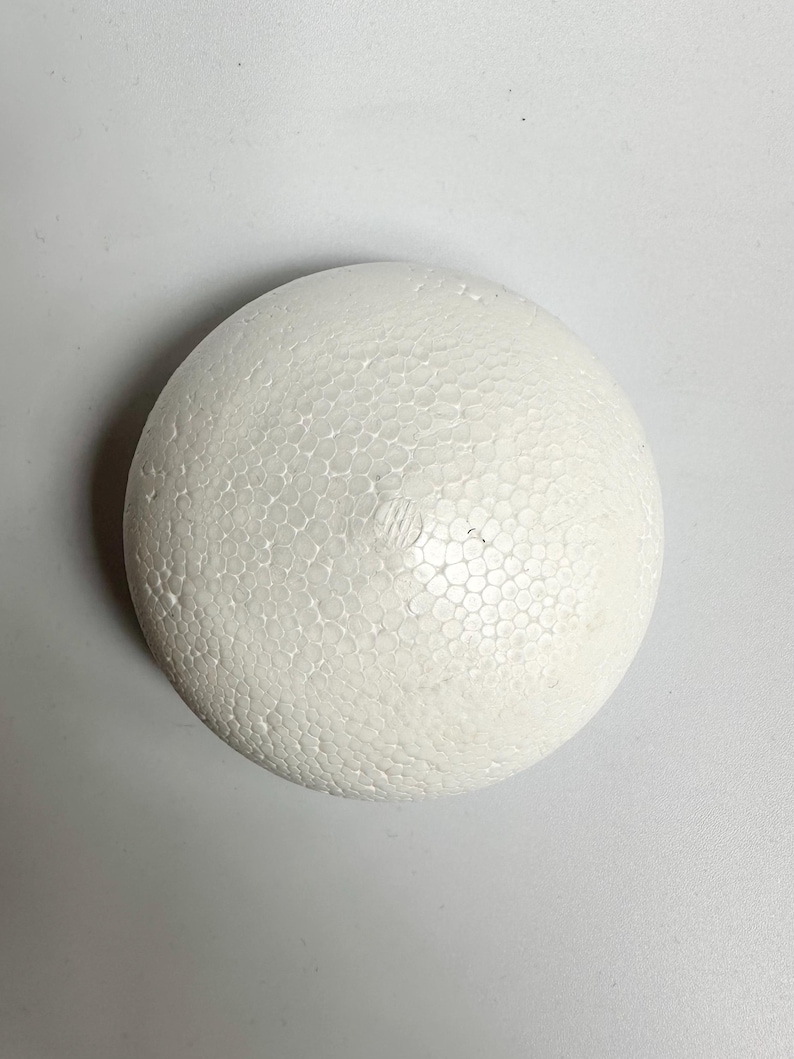 May include: A white styrofoam ball with a textured surface.
