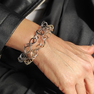 Op de afbeelding: Een zilveren en gouden armband met een gedraaid ontwerp.