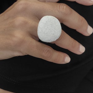 Könnte beinhalten: Ein weißer, runder, strukturierter Ring. Der Ring ist aus einem glatten, weißen Material gefertigt und hat eine leicht raue Textur.