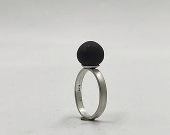 May include: A silver ring with a black sphere on top. The ring is marked with the numbers "925" and "4414".
