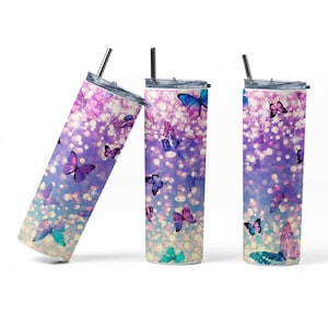 May include: Three stainless steel tumblers with a colorful ombre design featuring butterflies and glitter. The tumblers have lids and straws.