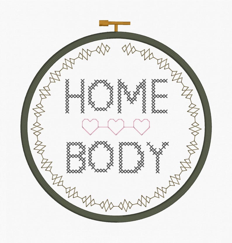 May include: A cross-stitch embroidery hoop with the words "HOME BODY" in black thread, with three pink hearts. The design is framed by a green hoop and a decorative border. A wooden clasp is at the top.