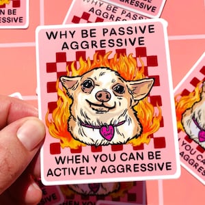 Może przedstawiać: Różowa naklejka z napisem „DLACZEGO BYĆ PASYWNIE AGRESYWNYM, KIEDY MOŻESZ BYĆ AKTYWNIE AGRESYWNYM”. Naklejka przedstawia kreskówkową chihuahuę z płomieniami wokół głowy. Pies ma na szyi różową obrożę w kształcie serca.