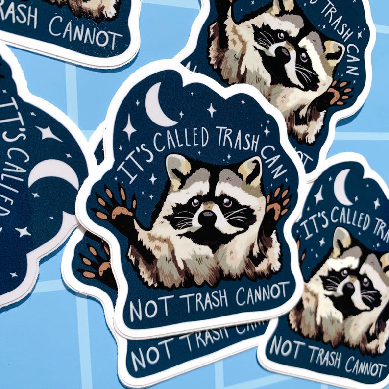 May include: A set of four stickers featuring a raccoon with the text "It's called trash can, not trash cannot." The stickers are on a blue background with stars and a crescent moon.