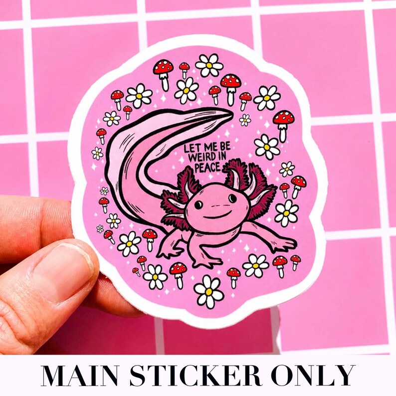 May include: A pink sticker featuring a cartoon axolotl with the text "LET ME BE WEIRD IN PEACE." The axolotl is surrounded by white daisies and red mushrooms. The sticker is held against a pink background.