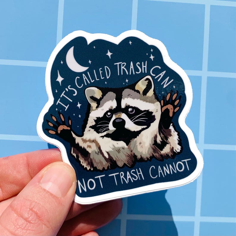 May include: A sticker featuring a raccoon with a starry night background. The raccoon is holding up its paws and the text reads "It's called trash can not trash cannot".