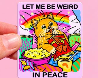 Könnte beinhalten: Ein quadratischer Aufkleber mit einer orangefarbenen Katze, die Chips isst, umgeben von einer Schüssel Popcorn, einem Becher und Snacks. Der Text lautet LET ME BE WEIRD IN PEACE. Der Hintergrund zeigt einen Regenbogen, Wolken und bunte Muster.