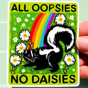 May include: A rectangular sticker featuring a black and white skunk standing in a green field with white daisies and a colourful rainbow. The text ALL OOPSIES is printed at the top and NO DAISIES is printed at the bottom in black capital letters.