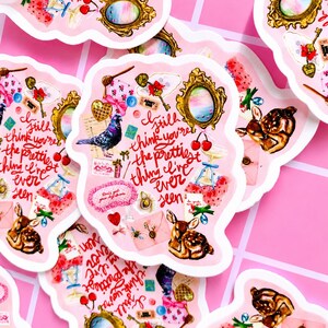 Pu&ograve; includere: Adesivi rosa con bordo smerlato, con varie illustrazioni come un cervo, un piccione, ciliegie e uno specchio vintage. Il testo "I still think you're the prettiest thing I've ever seen" &egrave; presente.