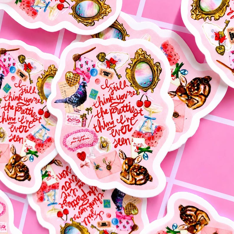 Pu&ograve; includere: Adesivi rosa con bordo smerlato, con varie illustrazioni come un cervo, un piccione, ciliegie e uno specchio vintage. Il testo "I still think you're the prettiest thing I've ever seen" &egrave; presente.