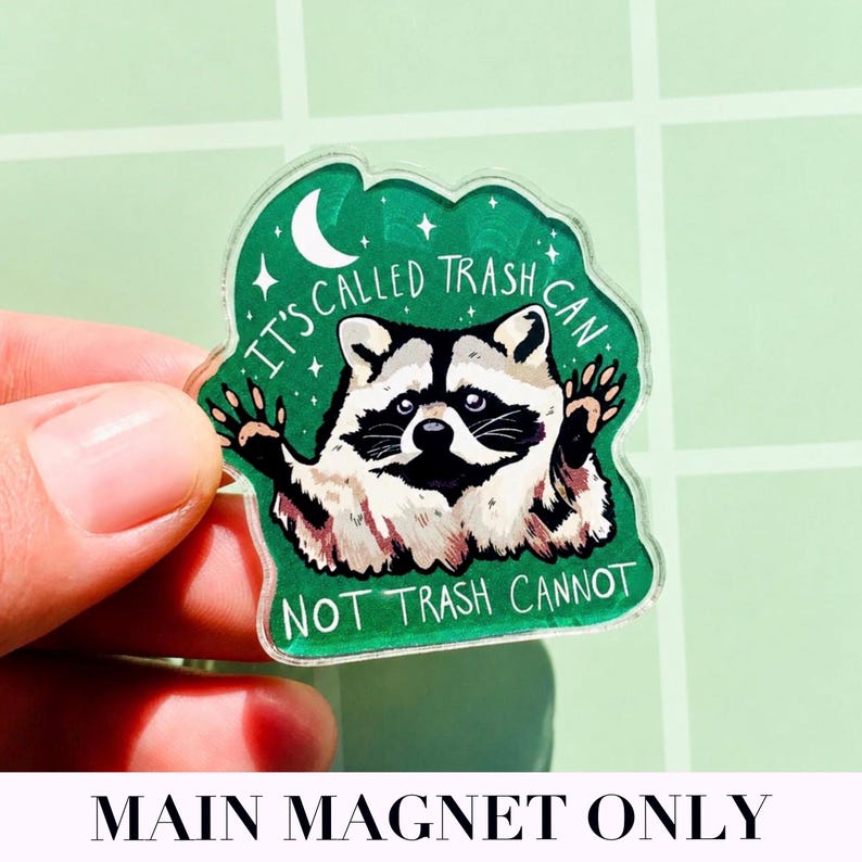 May include: A clear acrylic magnet featuring a raccoon illustration with the text "IT'S CALLED TRASH CAN NOT TRASH CANNOT" in white. The raccoon is black and white with a green background.