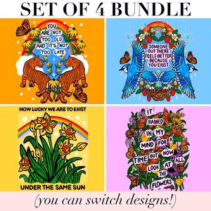 May include: A set of four graphic prints featuring vibrant illustrations. One shows tigers and flowers with the text 'YOU ARE NOT TOO OLD AND IT'S NOT TOO LATE'. Another displays blue jays and strawberries with 'SOMEONE OUT THERE FEELS BETTER BECAUSE YOU EXIST'. A third shows daffodils with 'HOW LUCKY WE ARE TO EXIST UNDER THE SAME SUN'. The last features butterflies and flowers with 'IT RAINED IN MY MIND FOR A TIME BUT NOW LOOK AT ALL THE FLOWERS'.