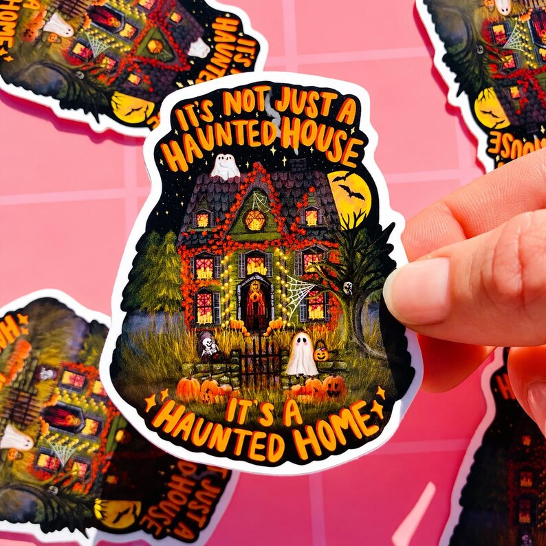 May include: A sticker with a spooky haunted house illustration. The house is decorated with lights, pumpkins, and ghosts. The text on the sticker reads "It's Not Just a Haunted House, It's a Haunted Home."