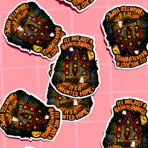 May include: A collection of Halloween-themed stickers featuring a spooky haunted house design. The stickers have a black background with a detailed illustration of a haunted house, ghosts, pumpkins, and the text "It's Not Just A Haunted House, It's A Haunted Home."