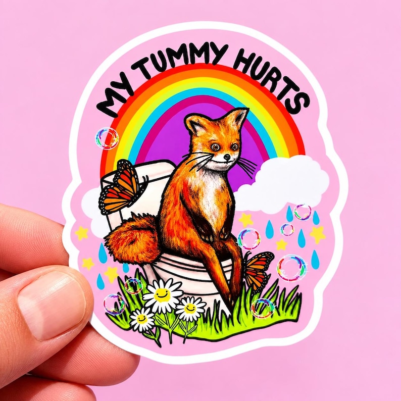 May include: A die-cut sticker featuring a fox sitting on a white toilet with the text MY TUMMY HURTS in black. The background includes a colorful rainbow, white clouds, blue raindrops, yellow stars, floating bubbles, and orange butterflies.