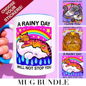 May include: A white ceramic mug with a blue handle featuring a colorful graphic of a cat resting on a cloud under a rainbow with the text A RAINY DAY WILL NOT STOP YOU. Three additional sticker designs show cats with text including I LOVE YOU.