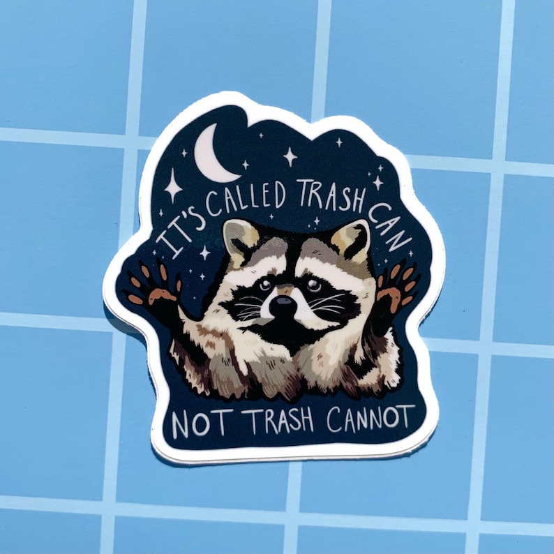 May include: A blue and white sticker with a raccoon in the center. The raccoon is holding up its paw and has a surprised expression. The text on the sticker reads "It's called trash can not trash cannot".