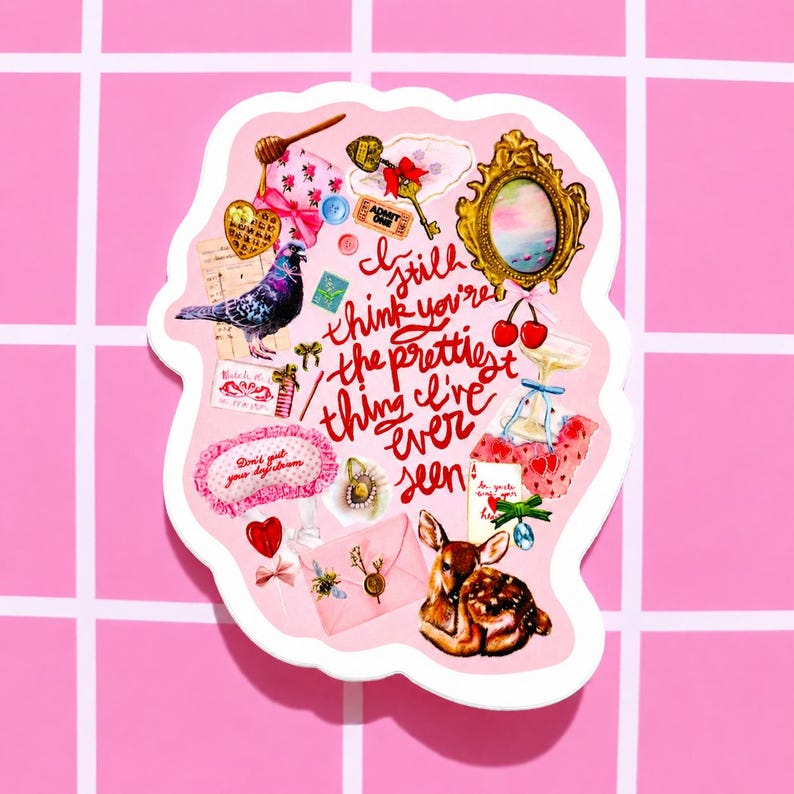 Pu&ograve; includere: Un adesivo rosa con varie illustrazioni, tra cui un piccione, un cervo, una chiave, una cornice dorata e ciliegie. L'adesivo include il testo "I still think you're the prettiest thing I've ever seen."