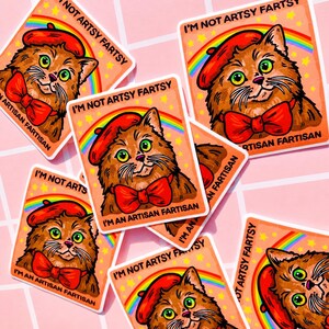 Pu&ograve; includere: Un adesivo quadrato raffigurante un gatto marrone che indossa un basco rosso e un papillon rosso. Un arcobaleno si inarca dietro il gatto su uno sfondo color pesca con stelle gialle. Il testo recita I'M NOT ARTSY FARTSY I'M AN ARTISAN FARTISAN.