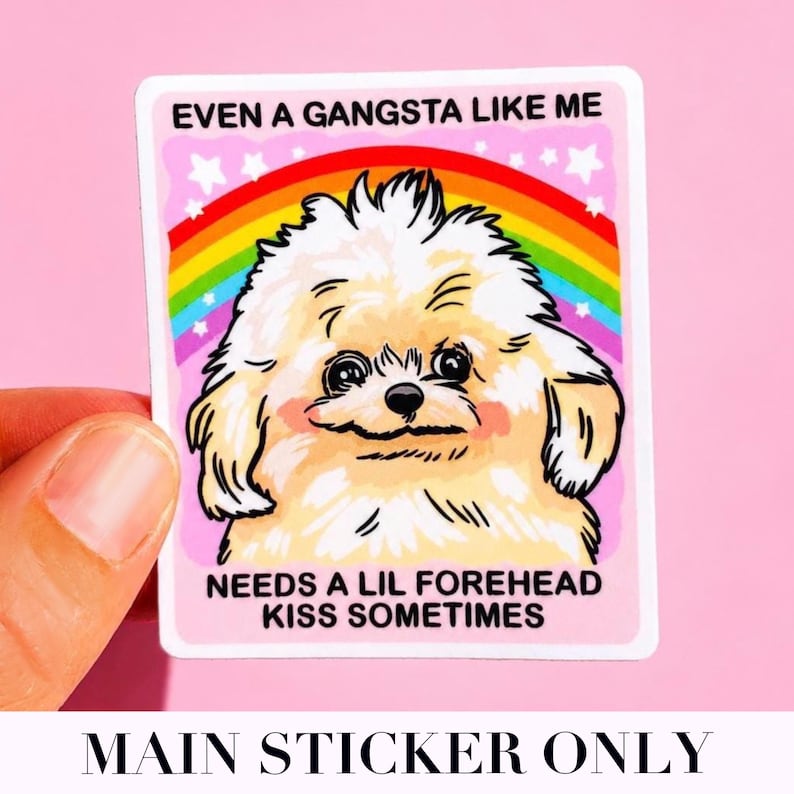 May include: A rectangular sticker featuring a fluffy cream-colored dog centered in front of a colorful rainbow and white stars. The text reads EVEN A GANGSTA LIKE ME at the top and NEEDS A LIL FOREHEAD KISS SOMETIMES at the bottom on a pink background.