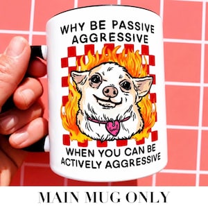 May include: White ceramic mug with a black handle and rim. The mug features a cartoon chihuahua in flames, a pink heart-shaped tag, and the text "WHY BE PASSIVE AGGRESSIVE WHEN YOU CAN BE ACTIVELY AGGRESSIVE."