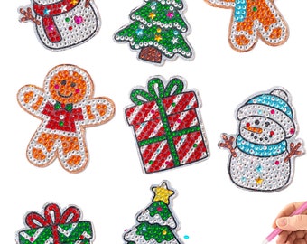Puede incluir: Un conjunto de ocho kits de pintura de diamantes con temática navideña. Los kits presentan un muñeco de nieve, un hombre de jengibre, un árbol de Navidad y una caja de regalo. Cada kit incluye un lienzo preimpreso, diamantes de imitación y una herramienta para aplicar los diamantes de imitación.