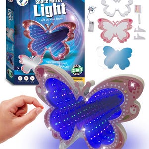 Pode incluir: Um kit de espelho luminoso em forma de borboleta com o texto "Make Your Own Space Mirror Light". O kit inclui um espelho de borboleta, uma caixa e formas de borboleta adicionais. O espelho de borboleta tem luzes LED azuis e tem cerca de 25 cm de largura.