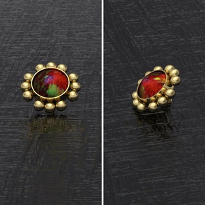 May include: A gold-toned ring with a red, green, and blue opal stone set in a circular bezel. The ring is surrounded by a row of small gold beads.