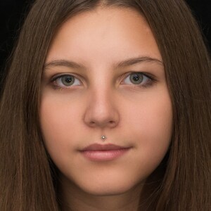 May include: Close-up portrait of a person with long brown hair. The person has a small, silver stud piercing in their lower lip.