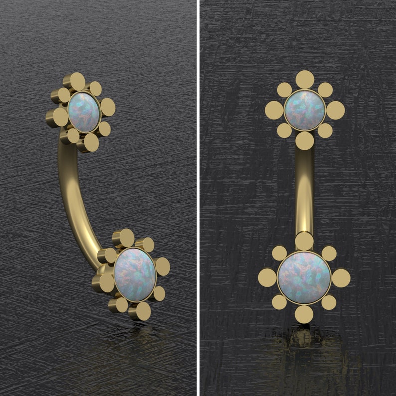 May include: Gold body jewelry with two opal stones set in a circular design. The jewelry is curved and has a rounded end.